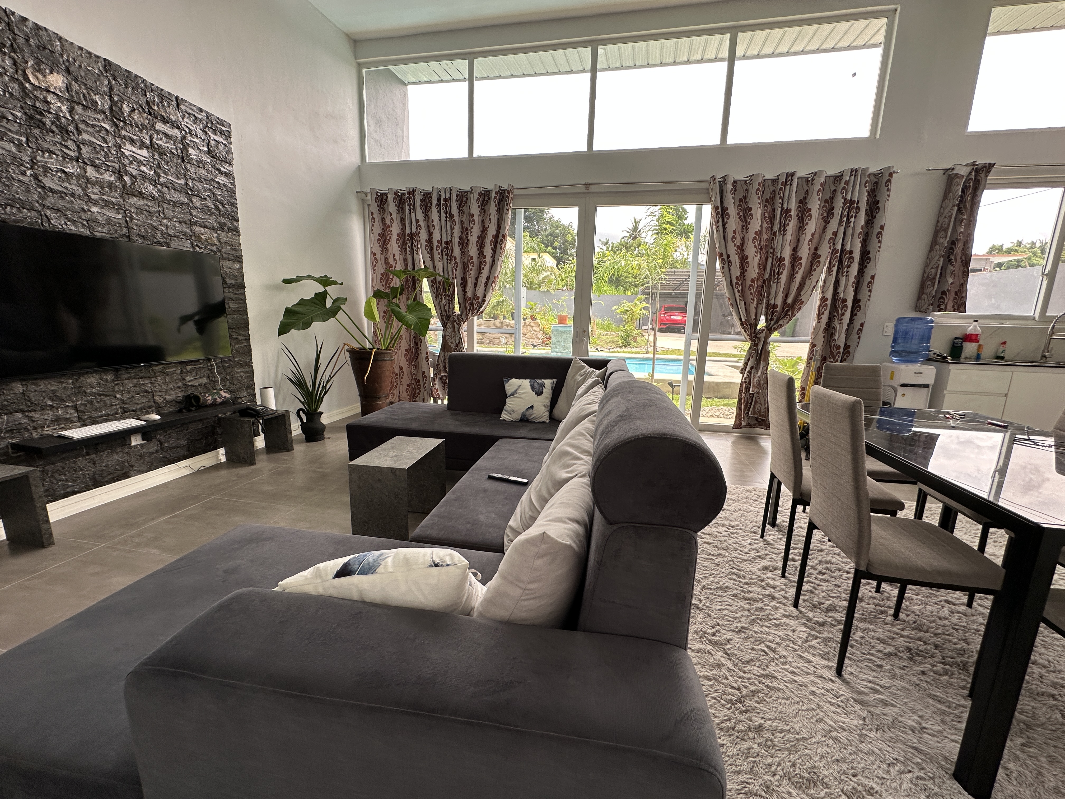 Living room with stone feature wall and pool view